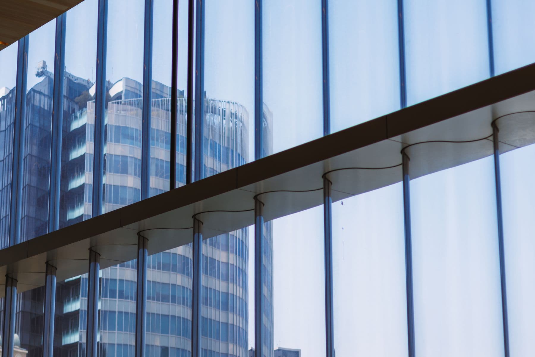 Glass office towers reflected in the windows of a commercial building